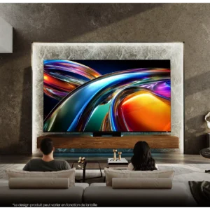 Deux personnes se détendent sur un canapé, regardant des images RVB vibrantes sur un grand téléviseur HISENSE 65UR9S RGB fixé au mur dans un salon moderne.