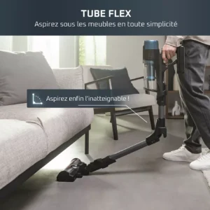 À l'aide de l'aspirateur sans fil ROWENTA RH9BC1WO, une personne nettoie le dessous d'un canapé dans un salon ensoleillé.