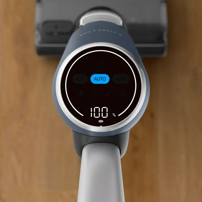 L'écran numérique de l'aspirateur ROWENTA GZ5436E0 affiche le mode "AUTO" et un niveau de batterie de 100 % alors qu'il repose sur un sol en bois.