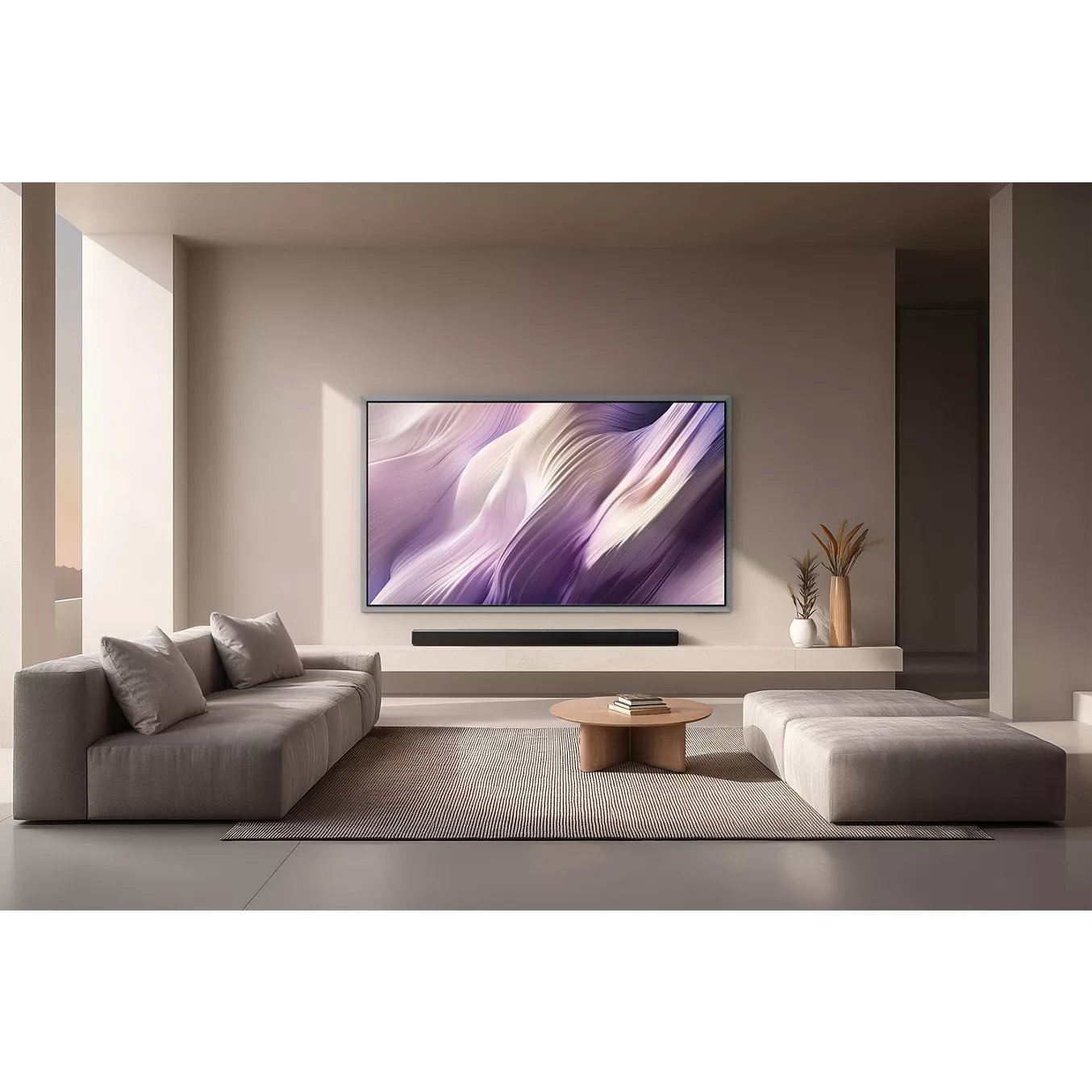 Le salon minimaliste est composé de canapés neutres, d'une table basse ronde et d'un grand téléviseur SAMSUNG TQ65S99H de 65 pouces affichant des œuvres d'art abstraites.
