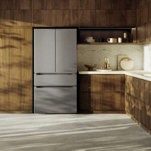 Cuisine moderne avec des placards en bois, des étagères ouvertes, la lumière du soleil qui inonde le sol et un réfrigérateur LIEBHERR MBSDDI9524-20 encastré.