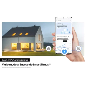 Une main tient un smartphone affichant les économies d'énergie réalisées grâce au SAMSUNG RS70F64KEKEF, tandis qu'une maison moderne s'illumine à la tombée de la nuit en arrière-plan.
