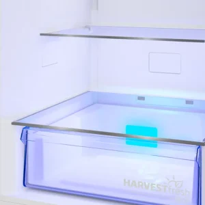 Le modèle SMEG FD14EW est équipé d'un tiroir réfrigéré ouvert comprenant un bac transparent teinté de bleu portant l'inscription « HARVESTfresh » et d'une clayette en verre située au-dessus.