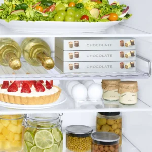 Ouvrez le réfrigérateur SAMSUNG RB34C602EB1 : vous y trouverez de la salade, du vin, du chocolat, une tarte aux fraises, des œufs, des bocaux de fruits, des olives et des yaourts.