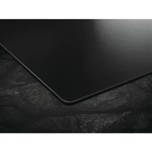 Gros plan sur le tapis de souris rectangulaire noir AEG TI84IU00IT posé sur une surface sombre et texturée, mettant en valeur ses coins arrondis.