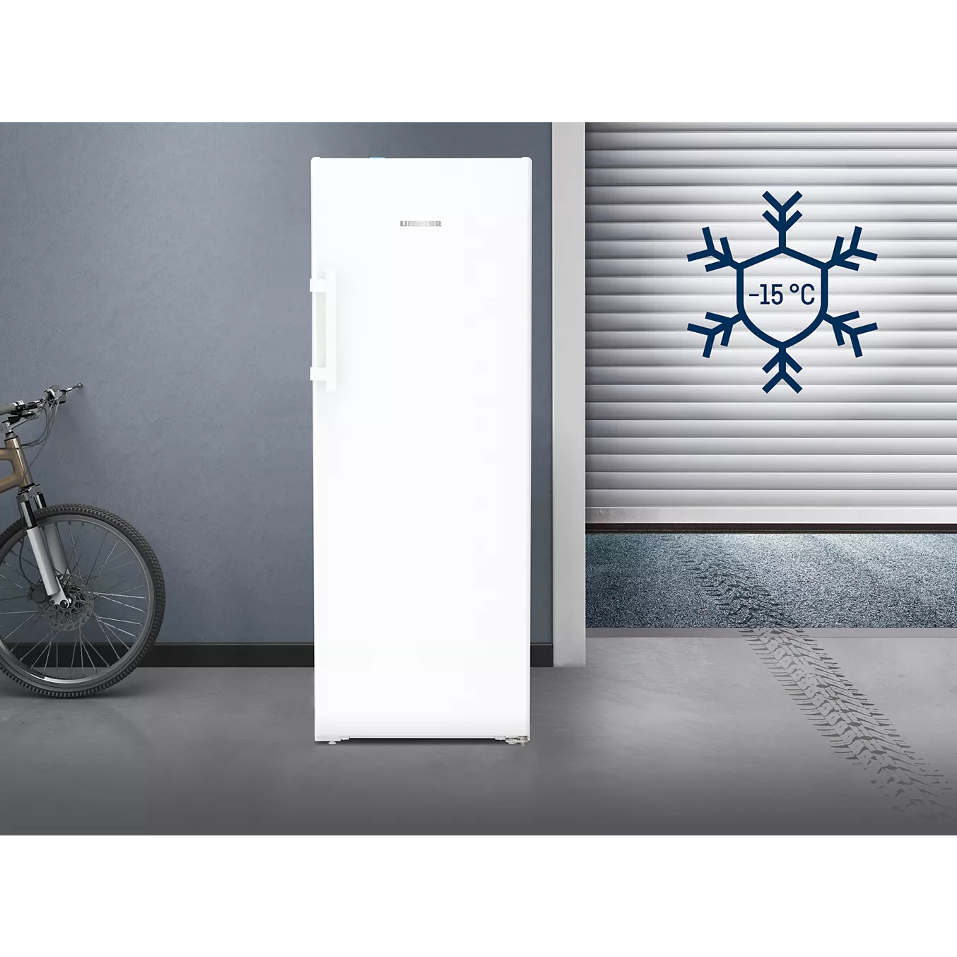 Un congélateur LIEBHERR FNE5217-20 blanc et vertical se trouve à côté d'un vélo ; sur le mur, un symbole en forme de flocon de neige indique une température de -15 °C.
