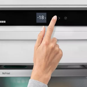 Une main règle le panneau de commande numérique du LIEBHERR FNE5217-20 pour le régler à -18 °C.