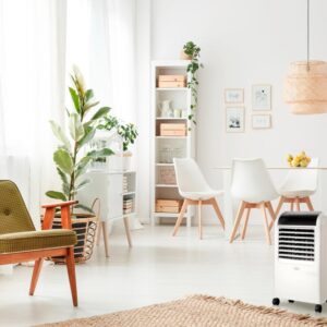 Un salon-salle à manger lumineux agrémenté de plantes, d'un mobilier moderne, d'un climatiseur portable posé au sol et d'une cuisinière électrique BEKO EFE6030W très pratique pour cuisiner rapidement et facilement.