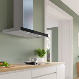 Cuisine moderne aux murs vert clair, avec des placards blancs, une cuisinière DWB97DN et des herbes aromatiques fraîches sur le plan de travail.
