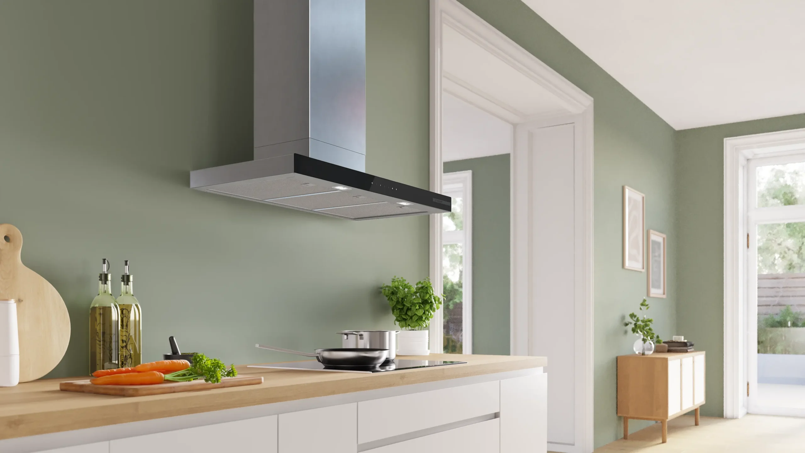 Cuisine moderne aux murs vert clair, avec des placards blancs, une cuisinière DWB97DN et des herbes aromatiques fraîches sur le plan de travail.