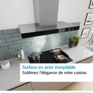 Cuisine moderne équipée d'une hotte en acier inoxydable DWB97DN, d'une cuisinière sur laquelle cuisent des plats, de vapeur qui s'élève et d'un dosseret en carrelage vert.
