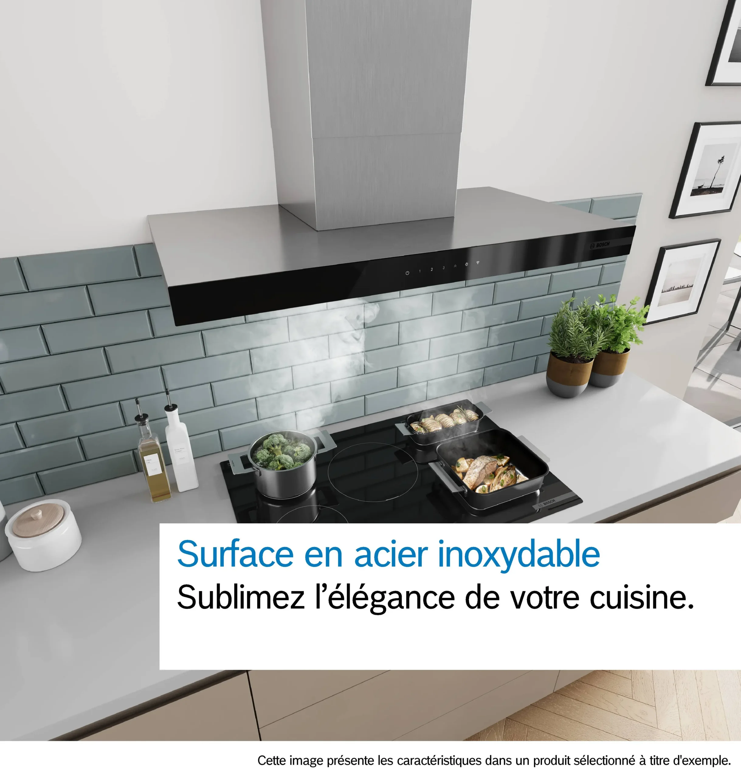 Cuisine moderne équipée d'une hotte en acier inoxydable DWB97DN, d'une cuisinière sur laquelle cuisent des plats, de vapeur qui s'élève et d'un dosseret en carrelage vert.