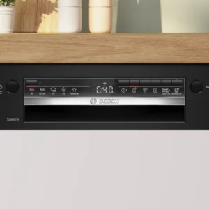Gros plan sur le panneau de commande du lave-vaisselle encastrable BOSCH SMI2HTB06E, installé sous un plan de travail en bois sur lequel sont disposés des objets décoratifs.