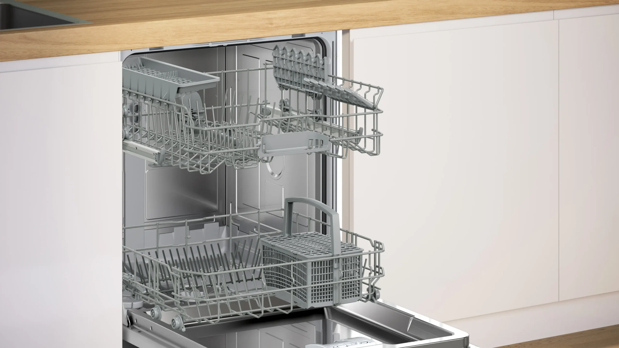Dans une cuisine moderne, le lave-vaisselle encastrable BOSCH SMI2HTB06E est ouvert, ses paniers vides attendant d'être remplis. Alliant un design épuré à une grande praticité, ce lave-vaisselle est un atout idéal pour votre intérieur.