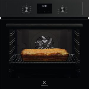 Une lasagne dans un plat en verre cuit dans un four moderne ELECTROLUX EOF3C40TH noir, dont la porte est ouverte.