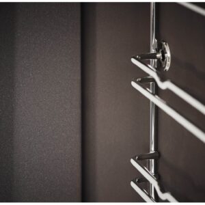 Gros plan sur un porte-serviettes métallique brillant fixé à un mur sombre et lisse, qui rappelle les éléments de design épurés du four ELECTROLUX EOF3C40TH.