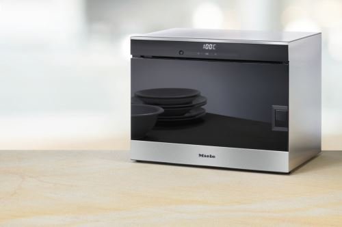 Le four à vapeur MIELE DG6019NR, doté d'un écran numérique réglé sur 100 °C, s'intègre avec élégance sur le plan de travail.