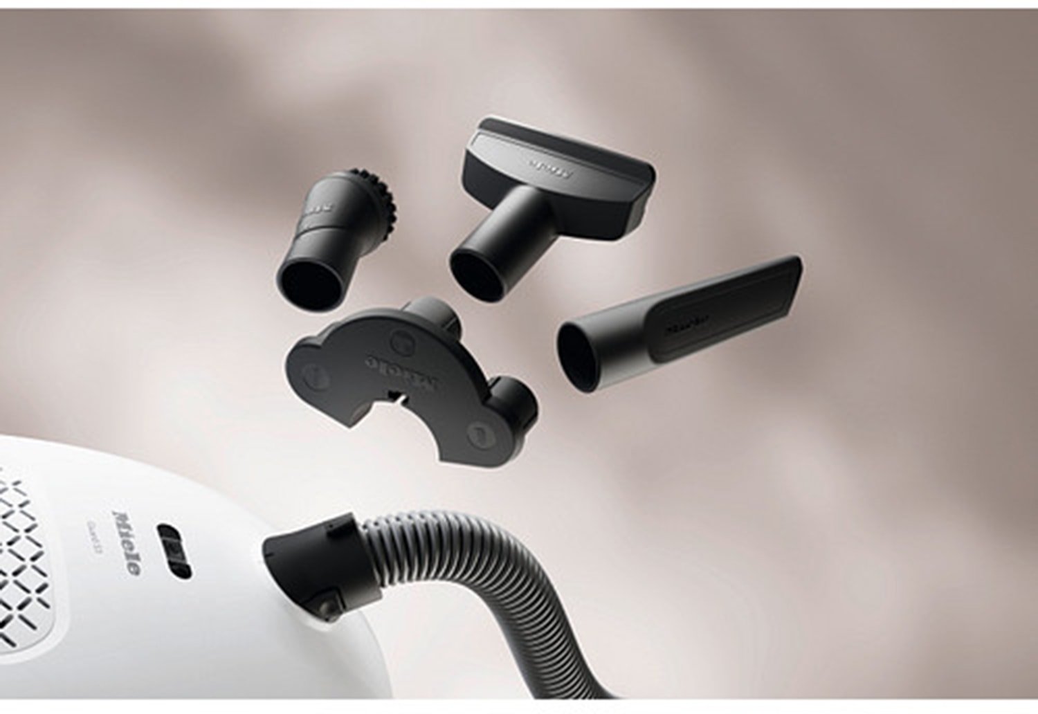 Quatre accessoires pour aspirateur Miele GUARD S1 BLEU NORDIQUE FLEX sont représentés au-dessus d'un tuyau flexible et d'un corps d'aspirateur assortis, sur un fond clair BLEU NORDIQUE.