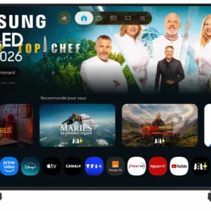 Un téléviseur SAMSUNG TU50M74H affiche un menu de streaming proposant des applications, avec en arrière-plan une émission culinaire mettant en scène quatre chefs et un animateur.