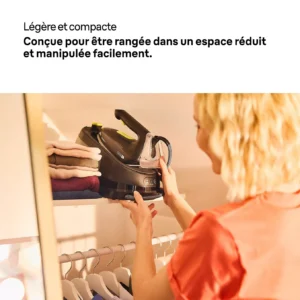 Une femme pose un fer à vapeur BRAUN IS3257BK sur une étagère au-dessus des vêtements suspendus dans son placard.