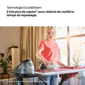 Une femme repasse une chemise chez elle, la lumière du soleil inondant la pièce à travers les grandes fenêtres derrière elle, et obtient un résultat parfaitement lisse grâce au fer à vapeur BRAUN IS3257BK, un appareil fiable.