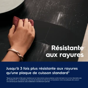Une main essuie la plaque à induction noire ELECTROLUX EIV73342IT, tandis qu'un texte en français souligne sa résistance aux rayures.