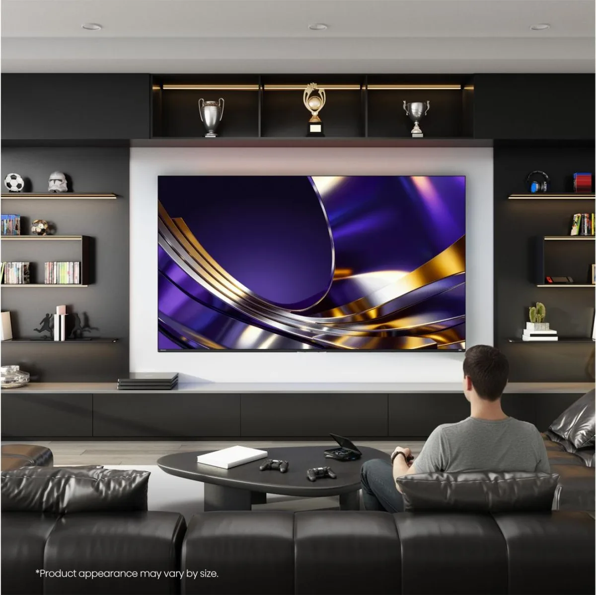 Une personne est assise sur un canapé dans un salon moderne décoré de trophées sportifs, en train de regarder un programme sur un téléviseur HISENSE 55U7S PRO.