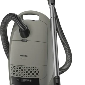 Aspirateur-traîneau Miele GUARD M1 SILENCE gris, équipé d'un tuyau, d'une poignée et d'un embout pour sol, se range à la verticale pour un nettoyage silencieux et efficace.