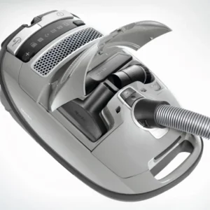 L'aspirateur-traîneau Miele GUARD M1 SILENCE, présenté ici en gris avec son couvercle supérieur ouvert, permet de ranger soigneusement les accessoires dans son compartiment pour une organisation pratique et intègre la technologie innovante SILENCE pour un fonctionnement silencieux.