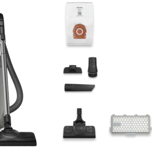 L'aspirateur-traîneau Miele GUARD M1 SILENCE, de couleur grise, est présenté sur un fond blanc avec son tuyau, ses six embouts, son filtre et son sac à poussière.
