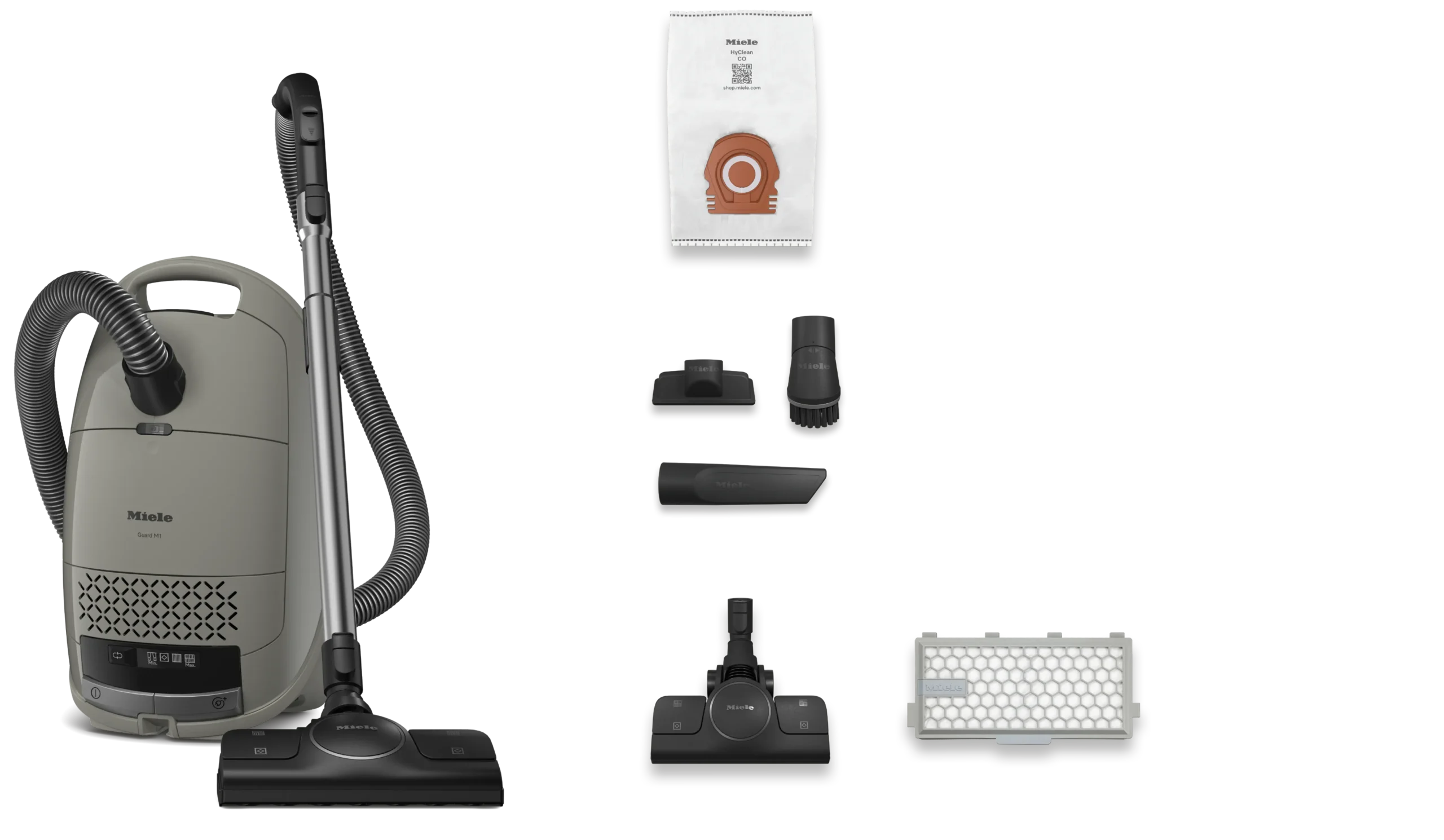 L'aspirateur-traîneau Miele GUARD M1 SILENCE, de couleur grise, est présenté sur un fond blanc avec son tuyau, ses six embouts, son filtre et son sac à poussière.