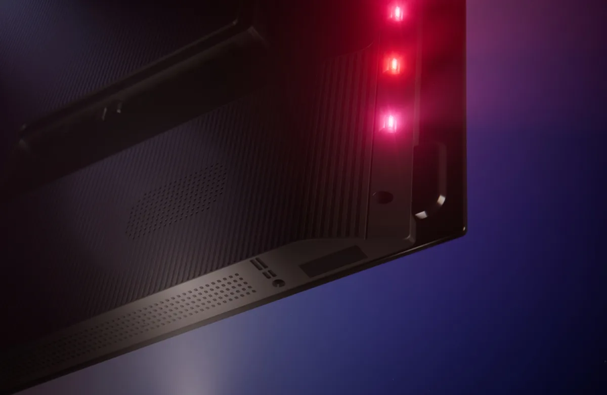 Gros plan sur un coin d'un appareil électronique noir, probablement issu d'un téléviseur OLED PHILIPS 55OLED850/12 (Copie), avec quatre voyants LED rouges qui brillent sur un fond sombre.