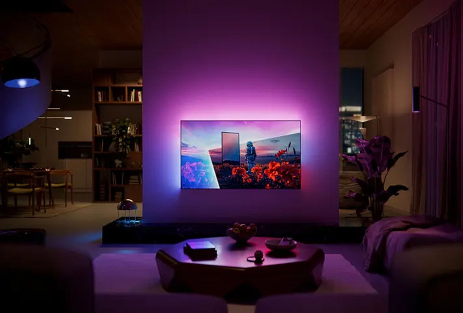 Un téléviseur PHILIPS 55OLED851 (Copie) fixé au mur, doté d'un rétroéclairage violet, illumine le salon moderne la nuit et offre une vue imprenable sur la ville.