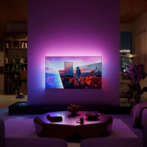Un téléviseur PHILIPS 55OLED851 (Copie) fixé au mur, avec un rétroéclairage violet, dans un salon élégant et moderne, la nuit.
