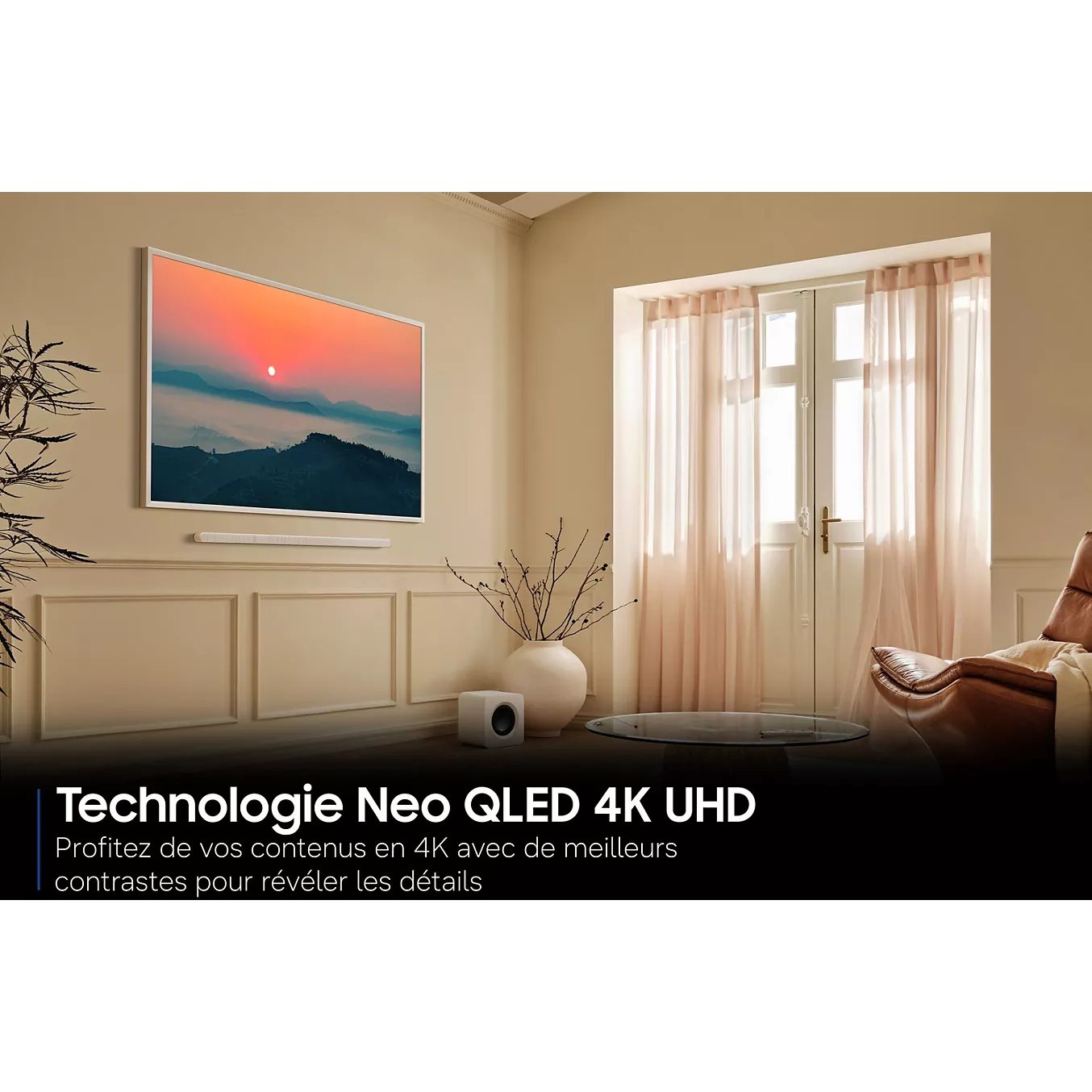 Un salon moderne agrémenté d'un téléviseur SAMSUNG TQ55LS03HW THE FRAME fixé au mur, mis en valeur par des rideaux roses et la lumière du soleil qui pénètre à travers les portes vitrées.