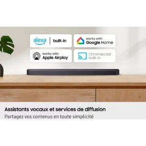 Une barre de son SAMSUNG HW-Q930H est posée sur une surface en bois, surmontée d’icônes représentant Alexa, Google Home, Apple AirPlay et Chromecast, soulignant ainsi les performances audio améliorées de ce modèle haut de gamme et son intégration parfaite dans un système domotique.