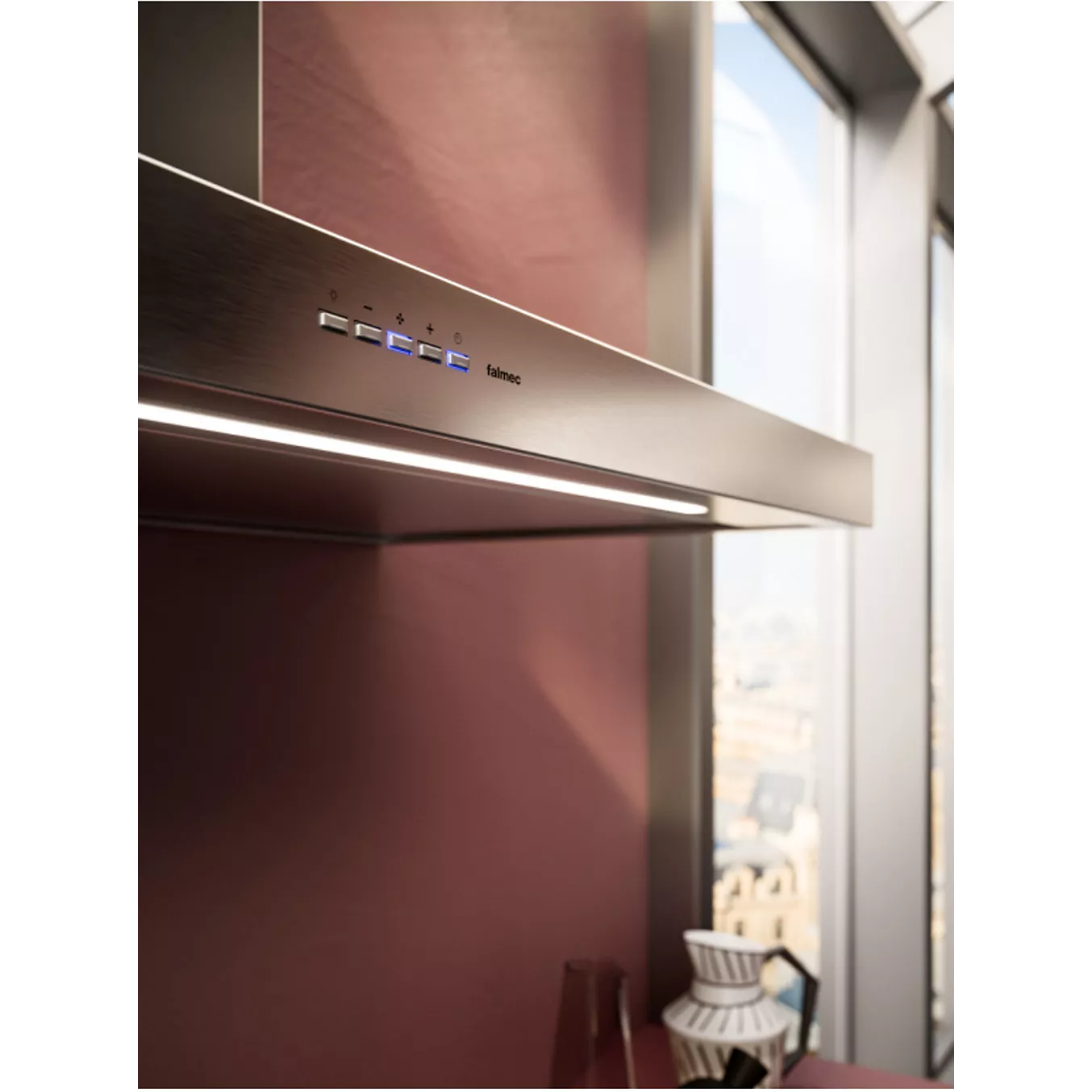 La hotte en acier inoxydable FALMEC PLANEP1430, dotée de boutons de commande et installée sur un mur de cuisine de couleur mauve près de grandes fenêtres, est l'appareil de cuisine moderne par excellence.