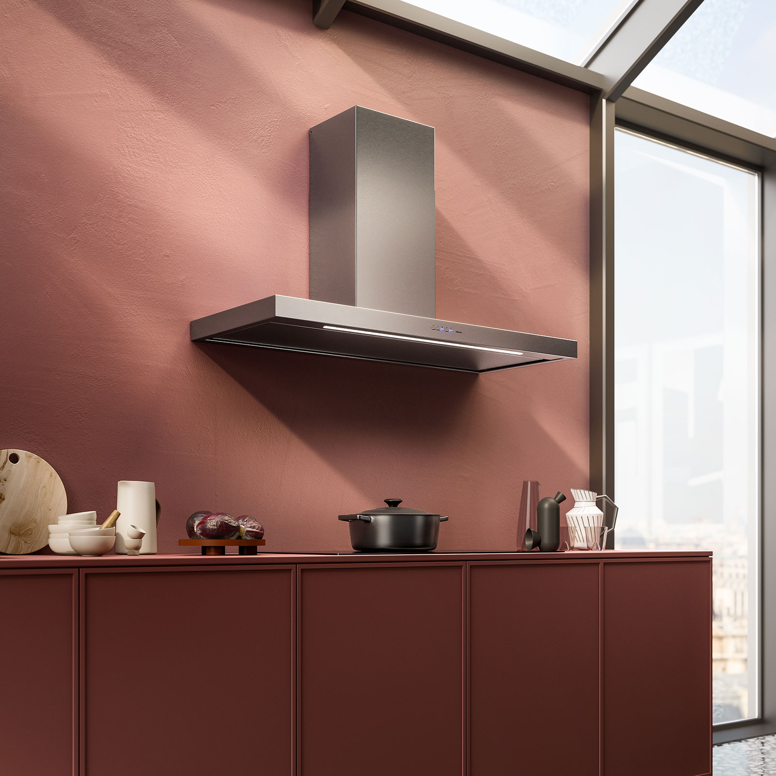 Une cuisine contemporaine dotée d'armoires bordeaux, d'une multitude d'ustensiles de cuisine et de l'élégante hotte FALMEC PLANEP1430, installée au-dessus d'une cuisinière en acier inoxydable, devant un mur rouge vif.